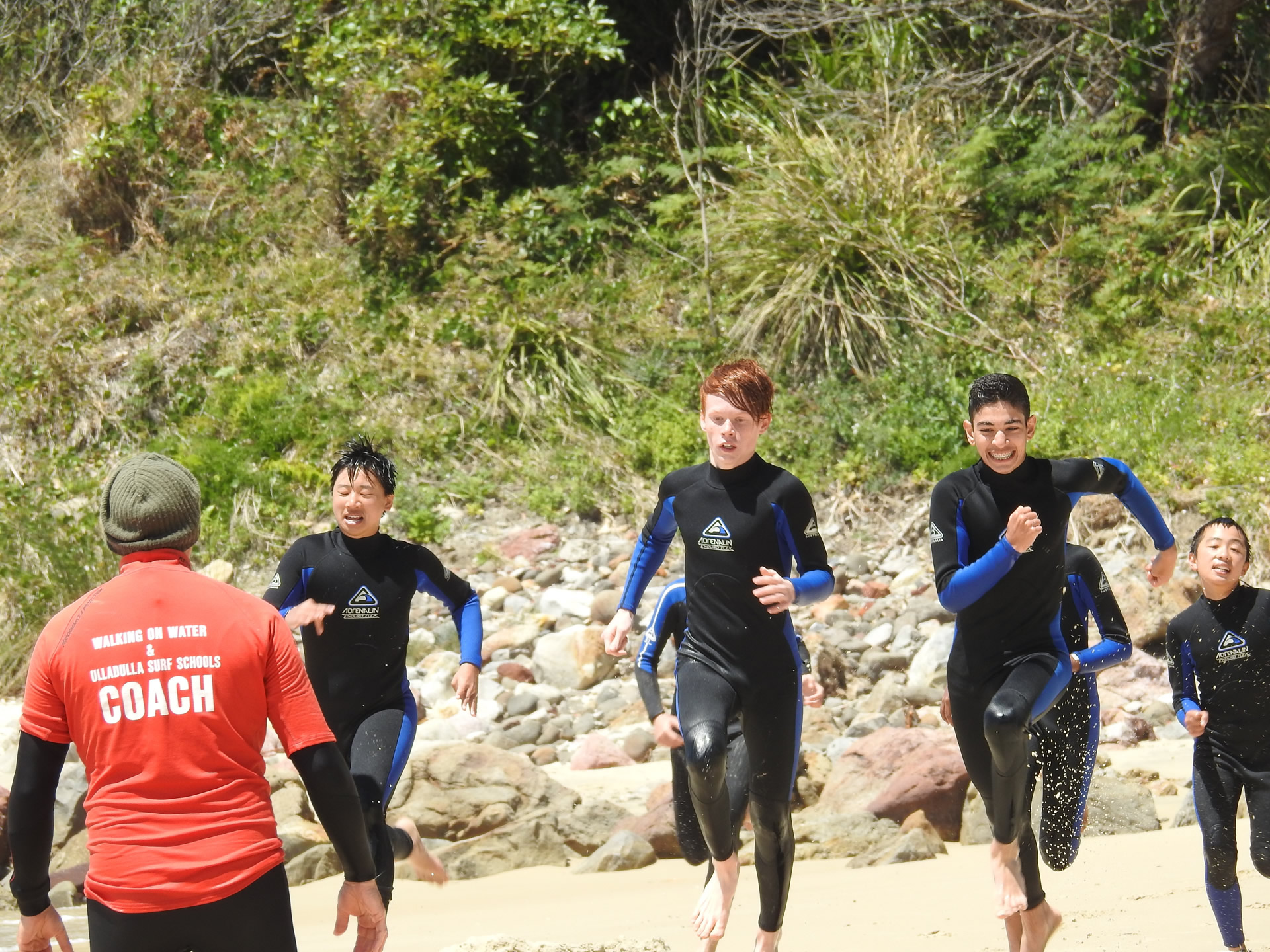 surf lessons and water safety course participants running on sand