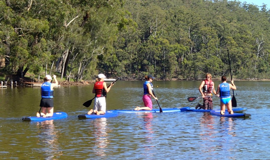 Group learn to stand up paddle board
