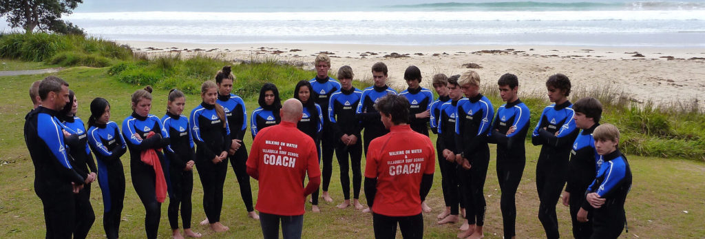 Safety water course participants listen to coaches with the beach in the background